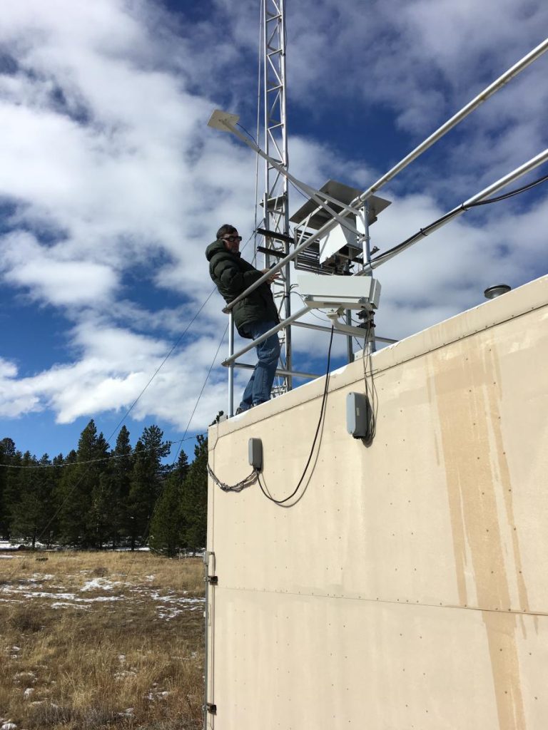 man on roof near weather equipment 