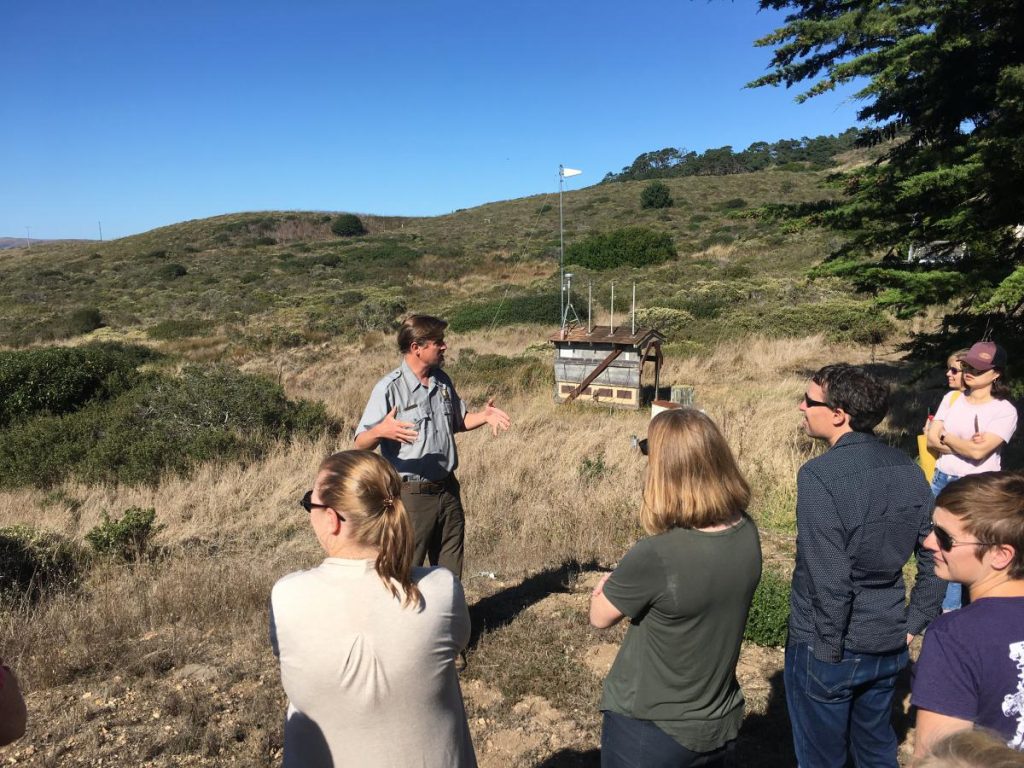 attendees in nature listening to a talk