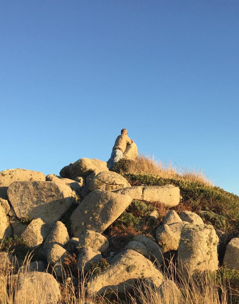 man over looking nature leaning on rocks