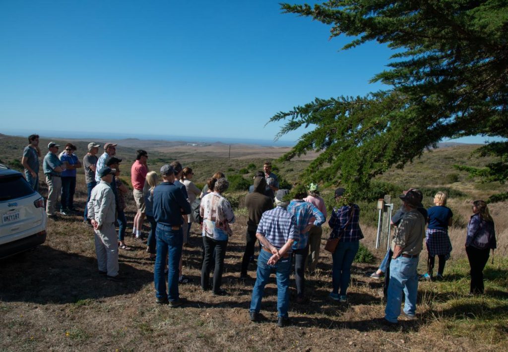 attendees standing outside listening to presentation